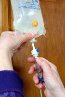 The end of the administration set fits into the opening at the bottom of the fluid bag. Use firm pressure to push fluid line into fluid bag.
