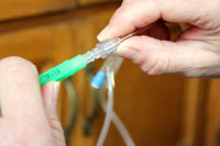 Don’t touch the open ends of either piece while handling. Attach fluid line to needle by pushing them together, then twisting.