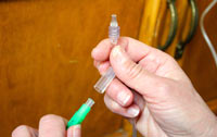 Keep all parts of the system clean by not touching them. Open a new needle by removing the plastic piece of the base.