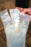 Your fluids will come inside an outer bag that needs to be removed. Open and discard the outer bag on your new bag of fluids.