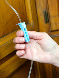 Open the fluid line by releasing the roller clamp.