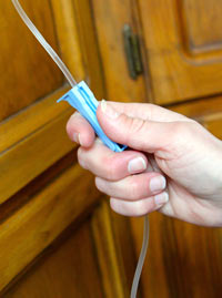 Use one hand to unclamp the fluid line while holding the needle in with the other. Unclamp the fluid line so the fluids can run into your cat.